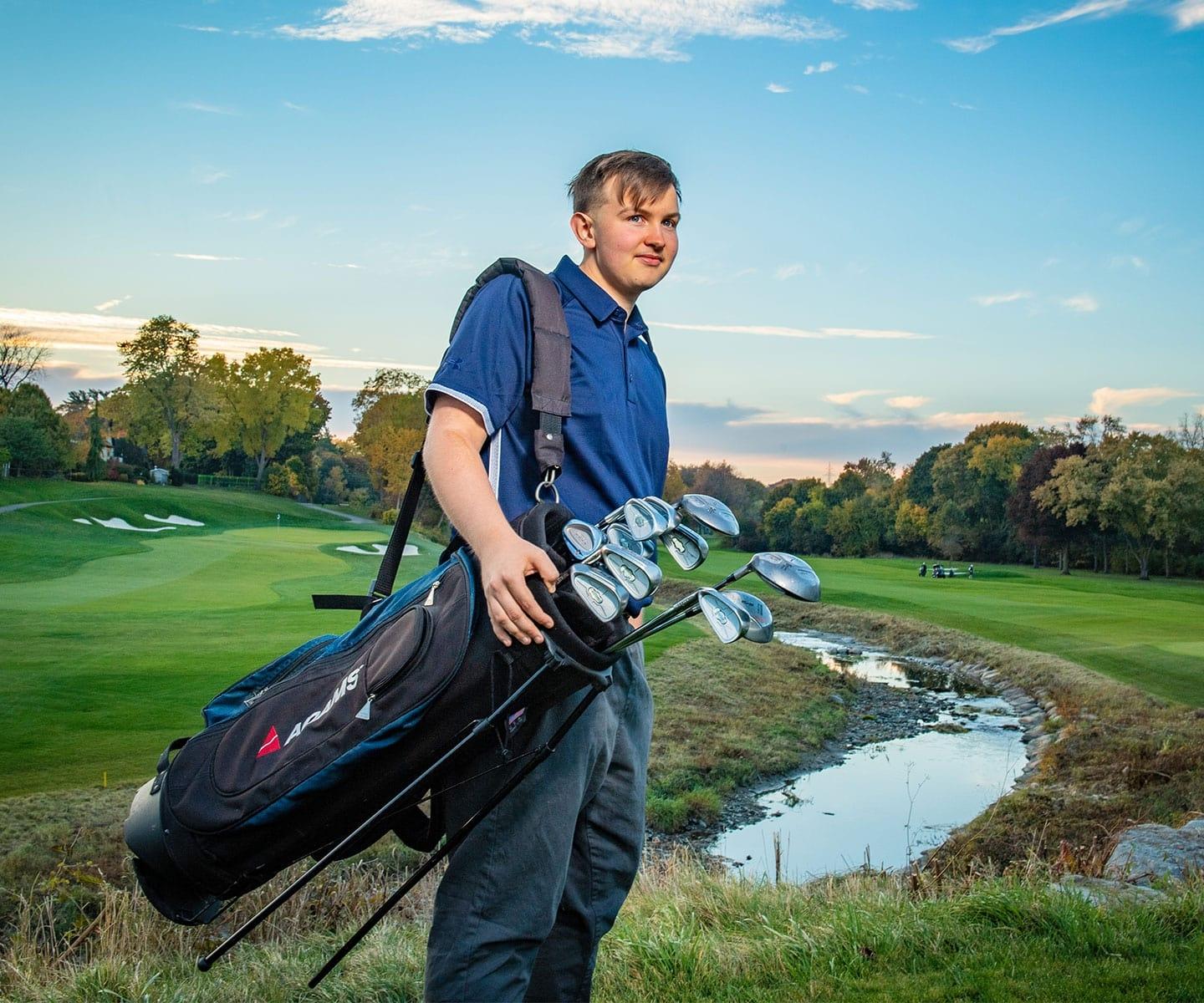 Teen blood recipient with golf clubs at golf course